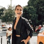 Cheerful stylish woman standing on sidewalk